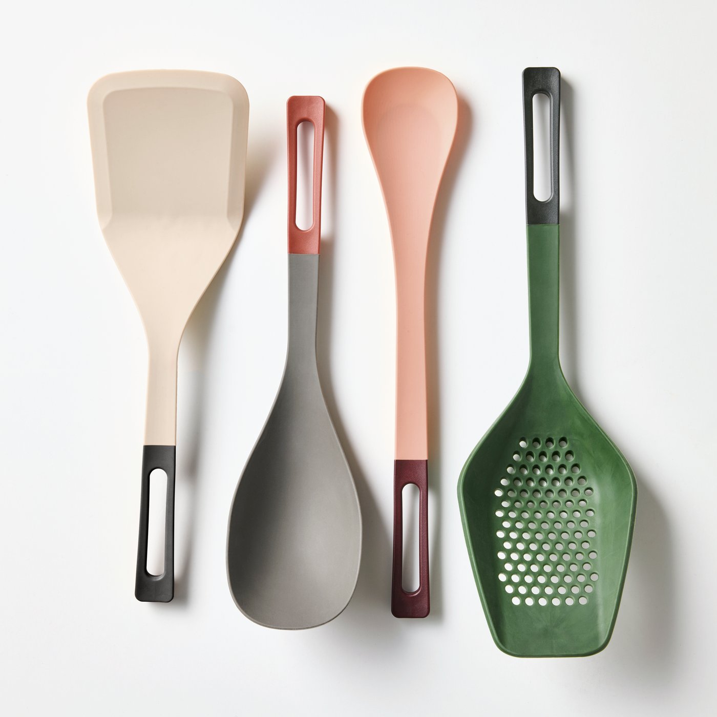 Four colourful KNORRHANE kitchen utensils neatly displayed on a white surface. 